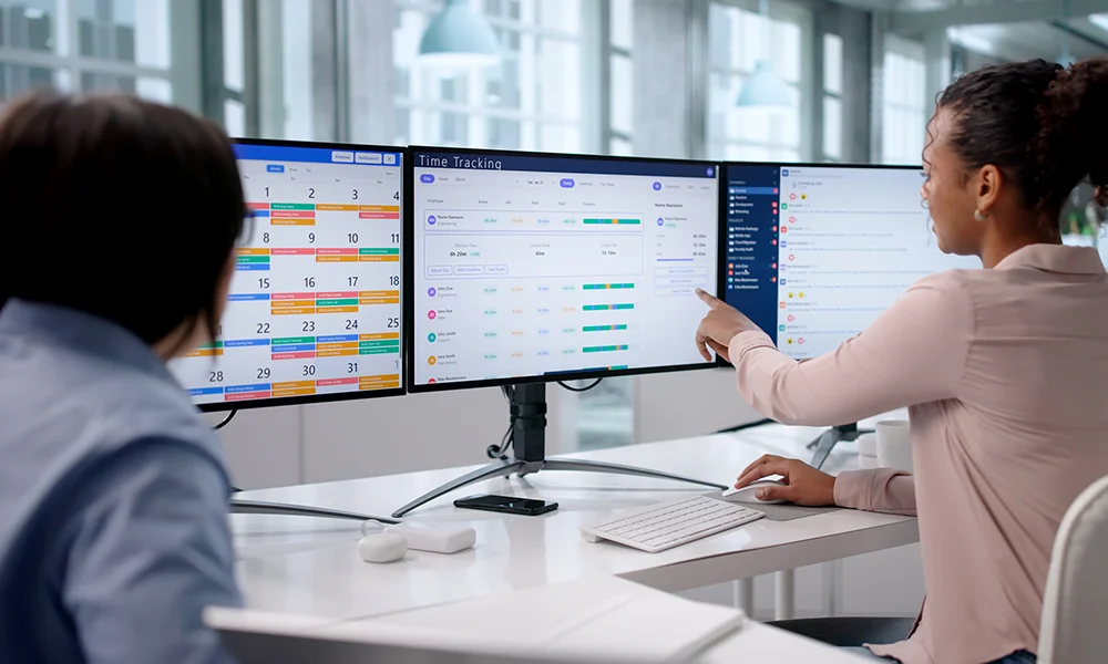 2 collaborateurs devant un planning sur ordinateur